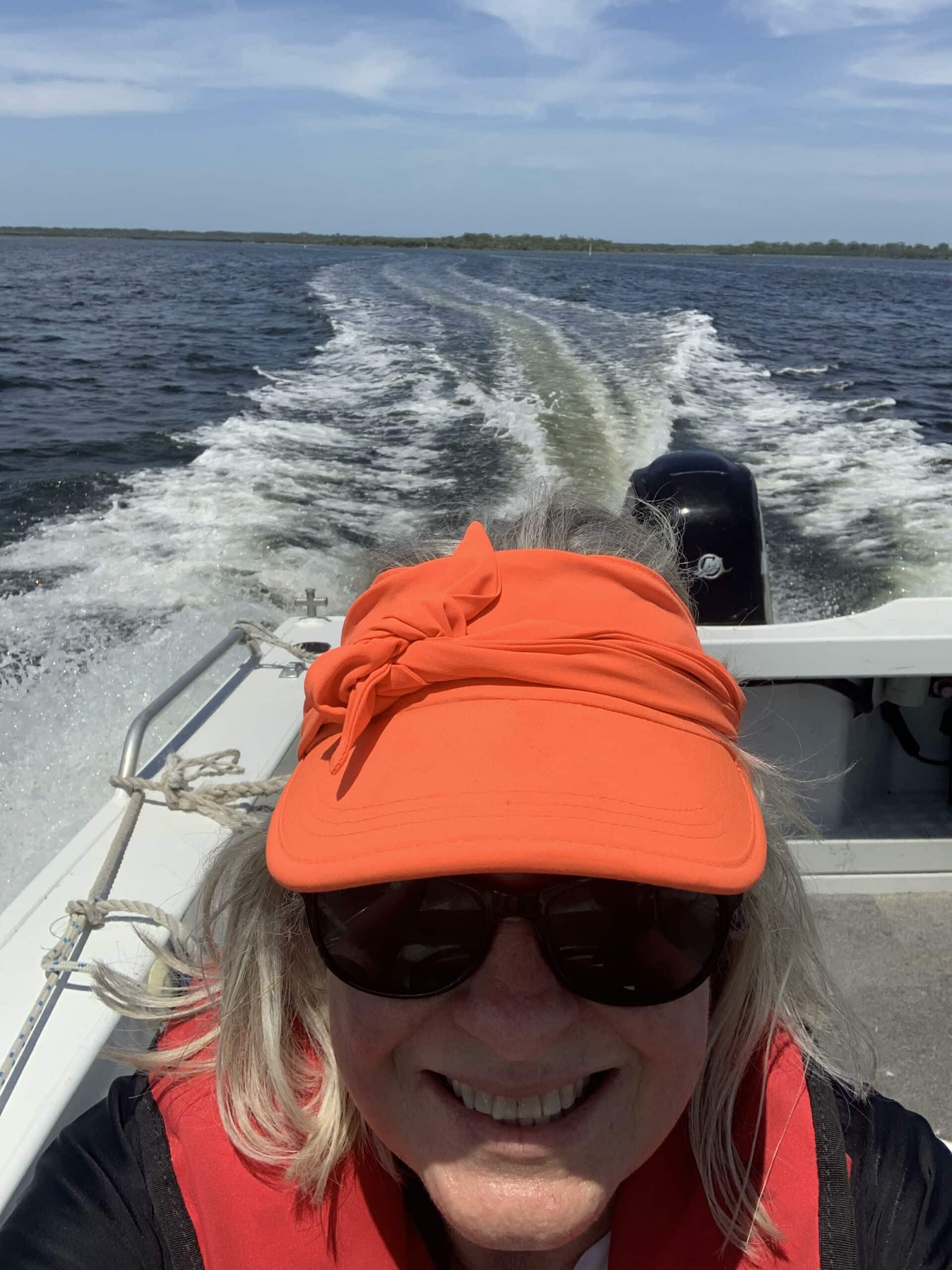 Louisa Coppel smiling at the camera whilst driving a boat