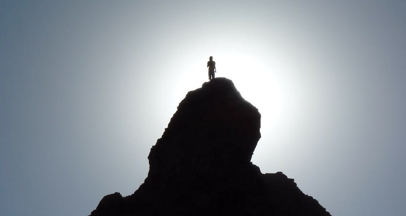 person on top of a rock backlit