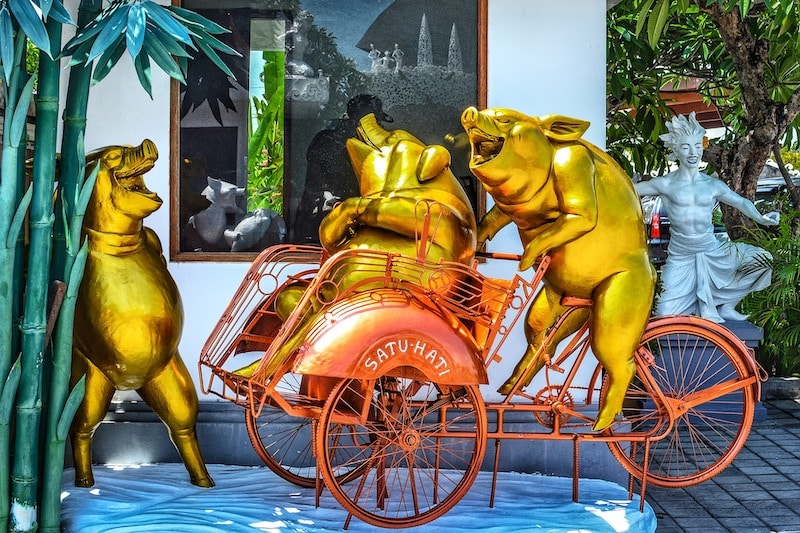 Pigs in tuk tuk statue